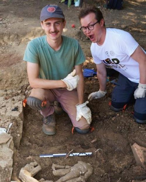 		Two people kneel in the dirt
	