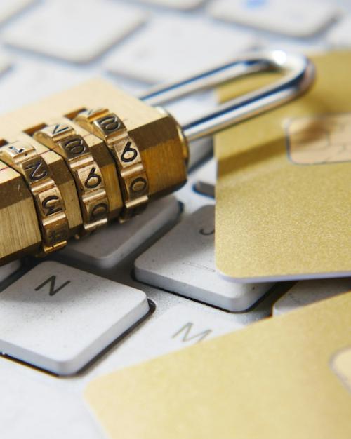 A gold padlock on a white computer keyboard