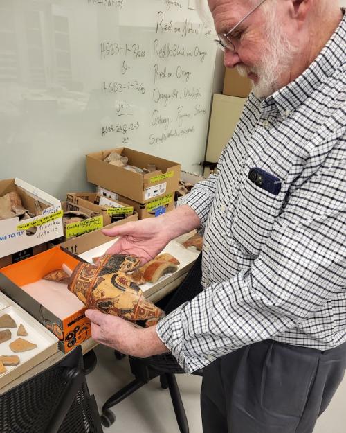 Person holding two matching pieces of pottery