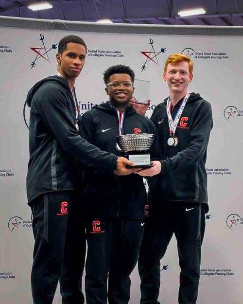 three people holding a trophy