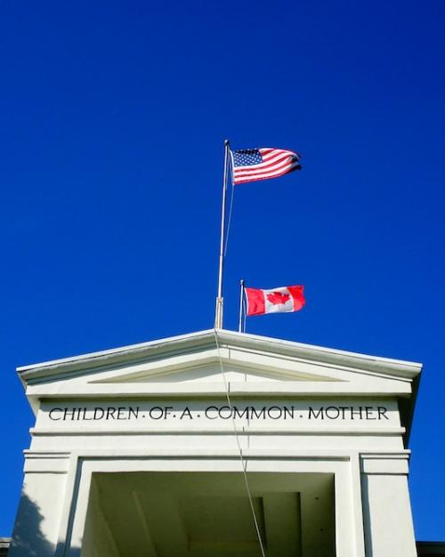White stone building with two flags flying over it
