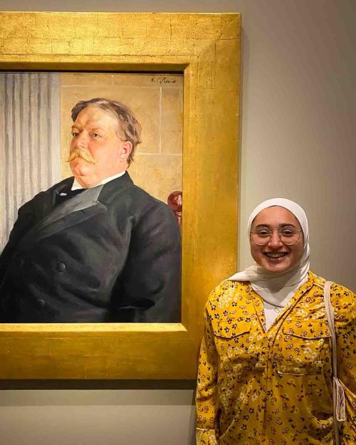 person smiling near painting