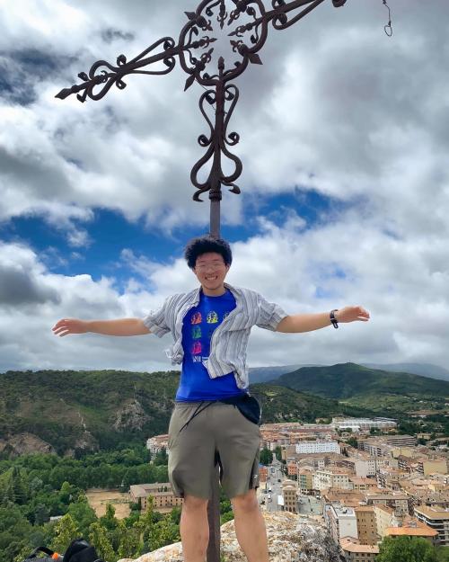 person on top of mountain overlooking a city