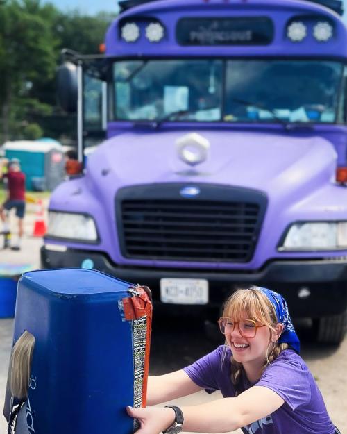 person with purple bus in background