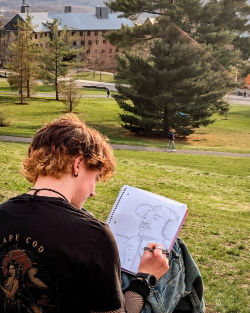 person outside writing in a notebook
