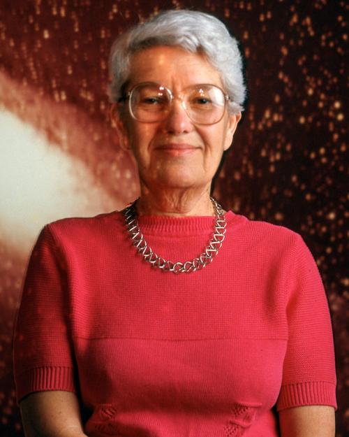 Person wearing red sits for a portait, backed by an image of a galaxy