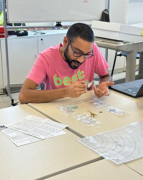 preparing materials for the exhibit Person working at a table, labeling small objects