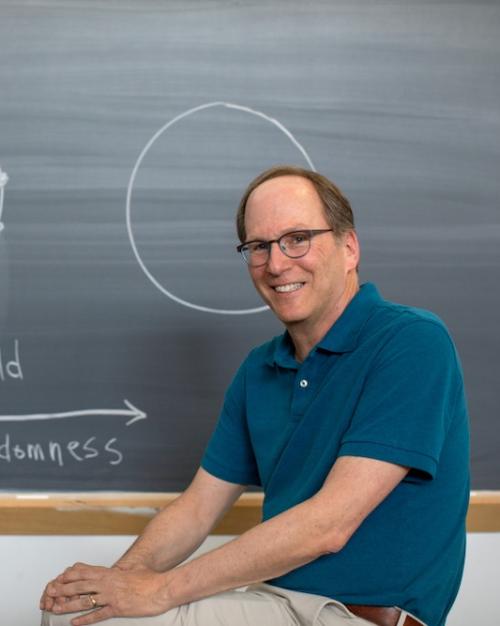 		Person sitting in front of a chalk board that has circular "smal world" diagrams on it
	