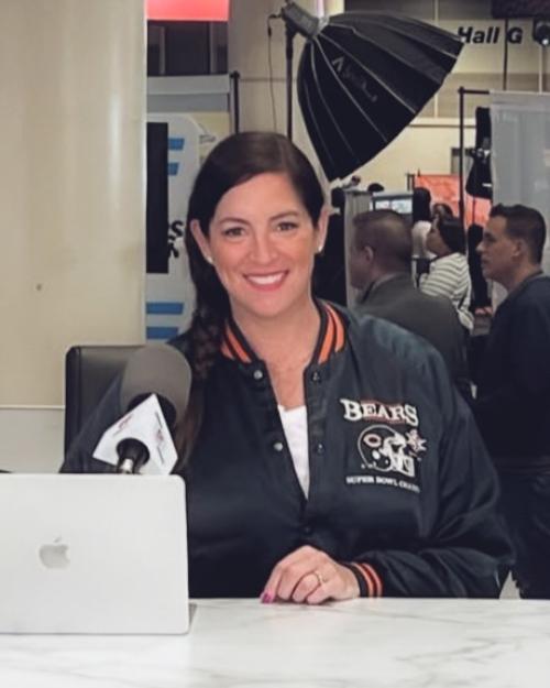 Person wearing a Bears jacket sitting at a computer in a press room
