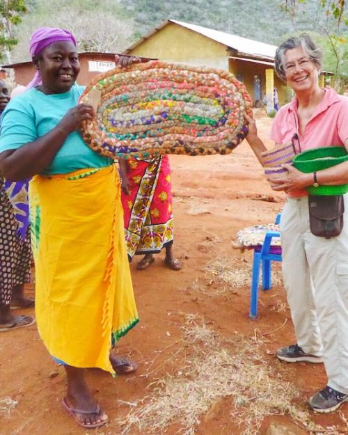 Two people holding a large, colorful basket between them
