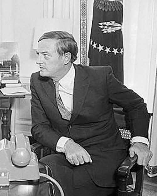 Historic photo of two men in suits at a desk, conferring: Richard Nixon and William F. Buckley
