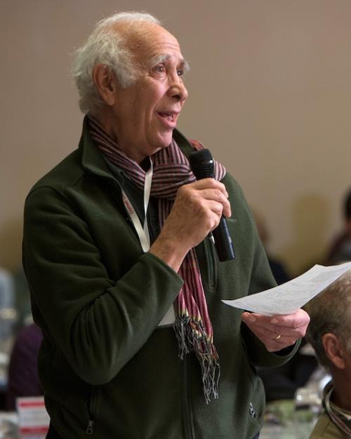 		Person holding a piece of paper and speaking into a microphone
	