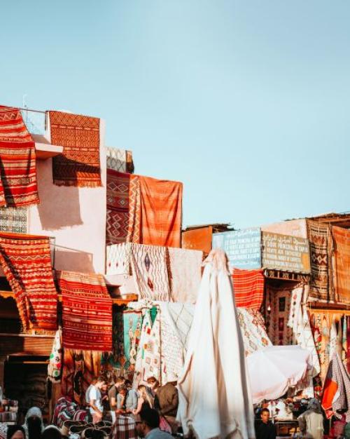 		Colored rugs make a collage under a blue sky
	