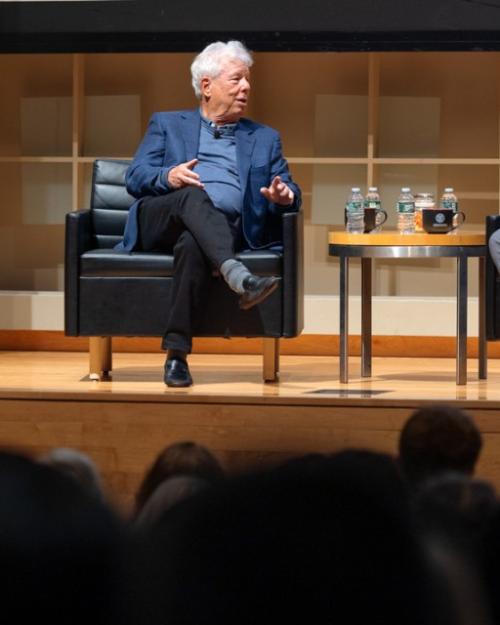 Two people conversing on a stage during an event