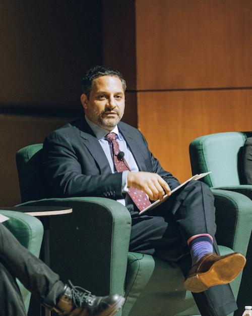 Three people sitting in arm chairs during an on-stage event