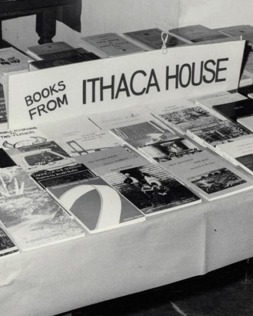 Black and white photo of a tale covered with books for sale from "Ithaca House" press