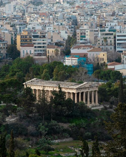 Ancient stone building near modern buildings in Athens, Greece