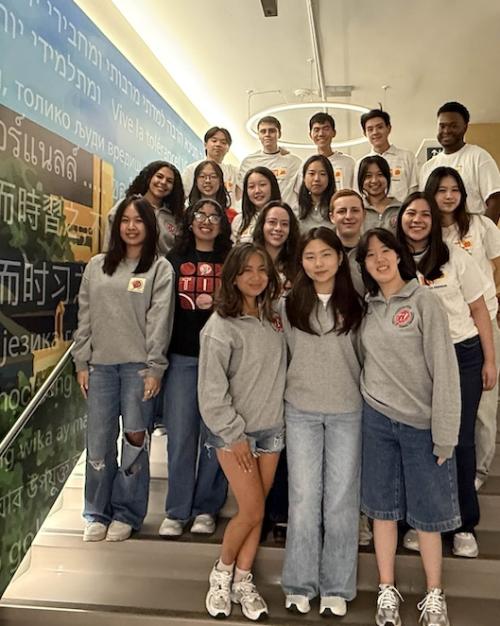		About 20 people pose as a group on a staircase. 
	