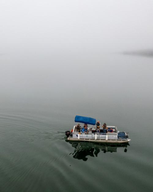Pontoon boat on still, gray water
