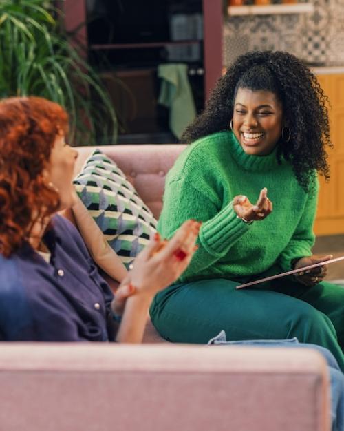 Two people sitting on a couch, conversing