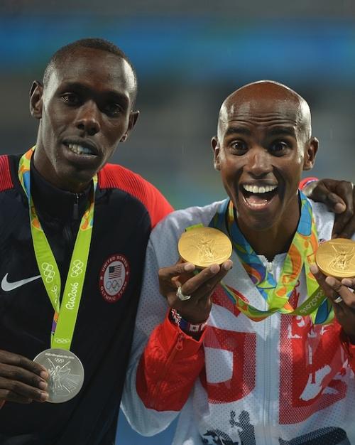 Three people holding up medals they've just won