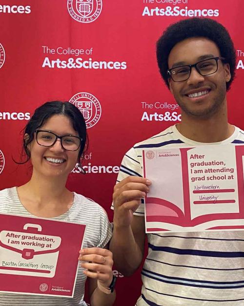 two people with signs saytng where they have jobs