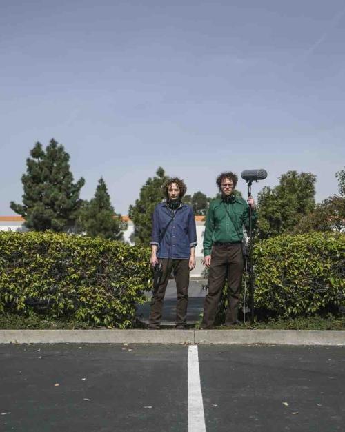 two people with microphone standing outside