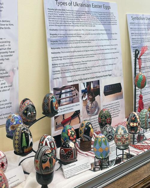 A display case filled with colorful Easter eggs and interpretive posters