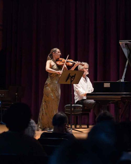 person playing violin, another person playing piano