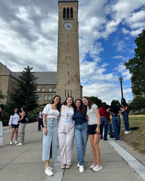people standing in front of the clock tower at Cornell