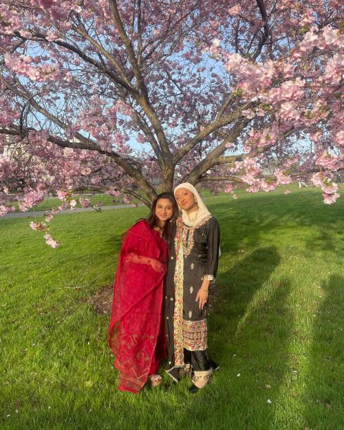 		two people standing under a flowering tree
	
