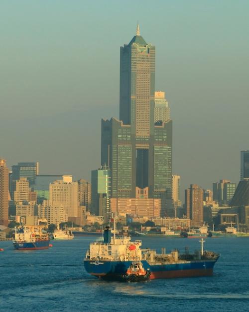 City skyline with a waterway in the foreground, filled with boats