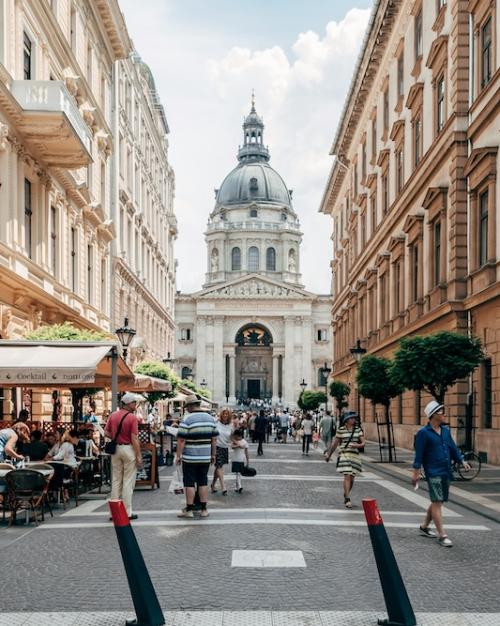 City street with pedestrians and a busy sidewalk cafe