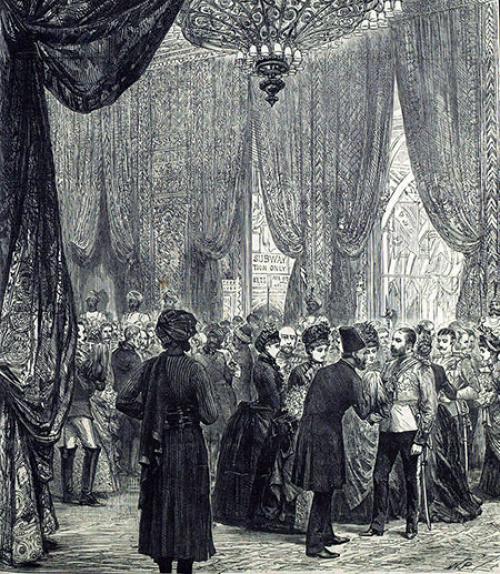  Image of a ball in colonial India, with a chandelier; men and women in fancy evening clothes, and Indians in turbans