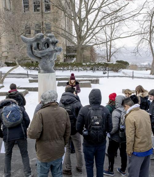  Students in Verity Platt&#039;s course, Statues and Public Life, examine and analyze a statue outside Uris library.  