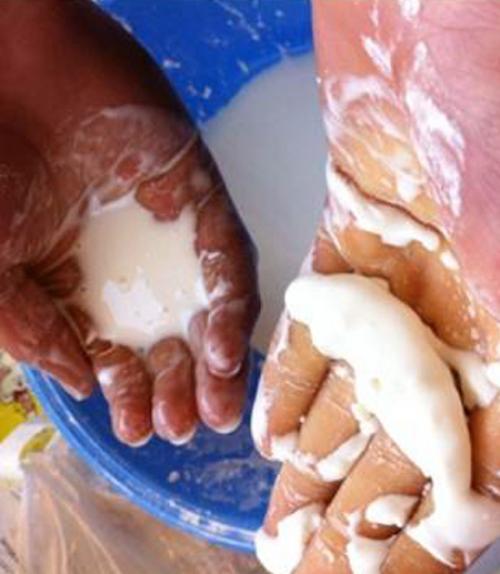  Hands hold oobleck, a white substance in liquid and solid form