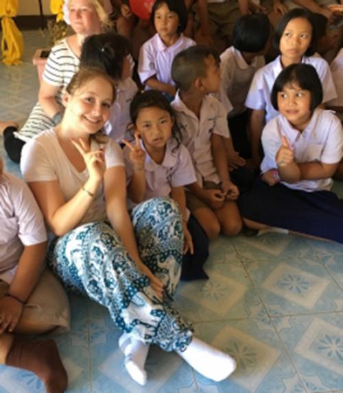  Sofia Aumann ’19, center, spent part of her summer on a service trip to Thailand, where she studied the issue of sex trafficking. She also worked in this school in Chiang Rai where group members taught English lessons, danced, and played with the kids.