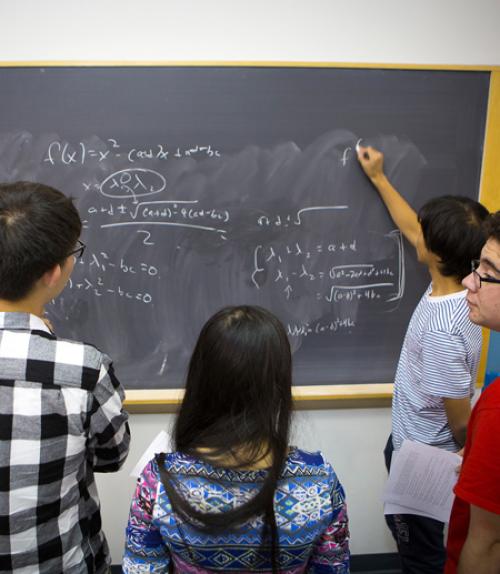  Students writing on blackboard
