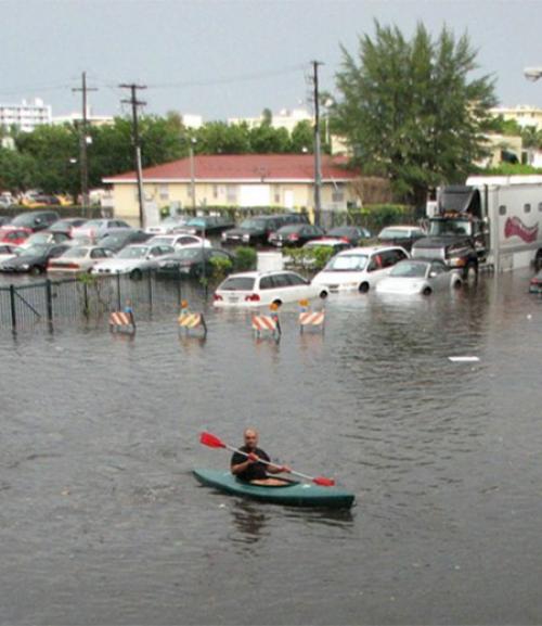  A person kayaking through floodwaters