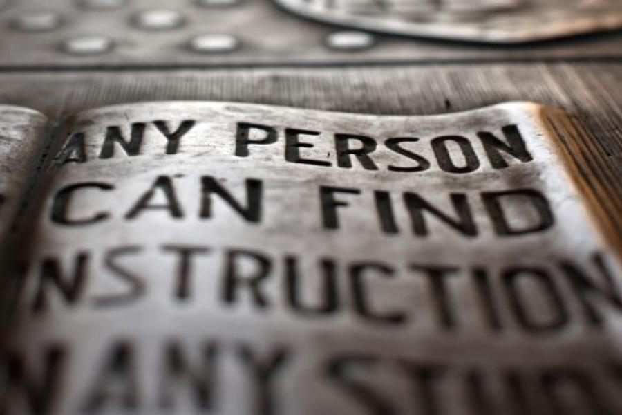 Plaque bearing the "...any person...any study" motto