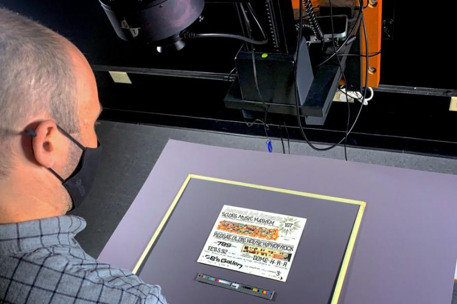 Person looking down at print materinal on a scanner