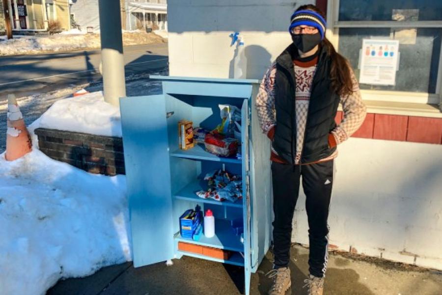 Person standing next to an outdoor food cupboard