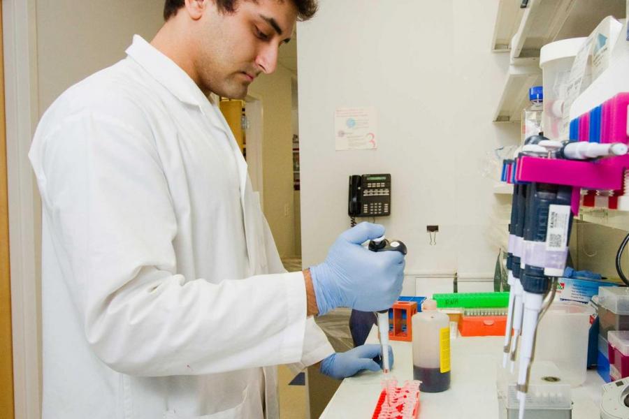 person in lab, using pipette