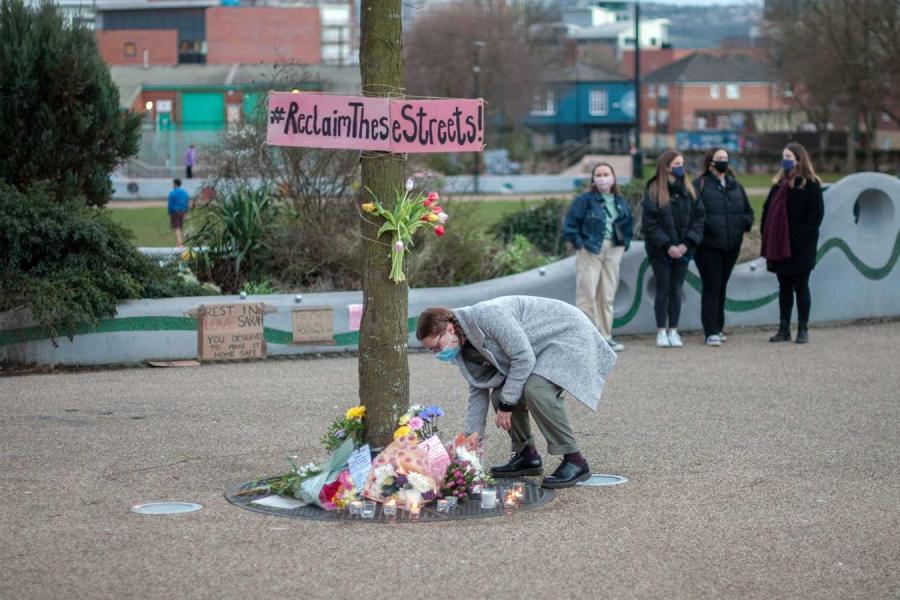 Person places flowers beneath a tree