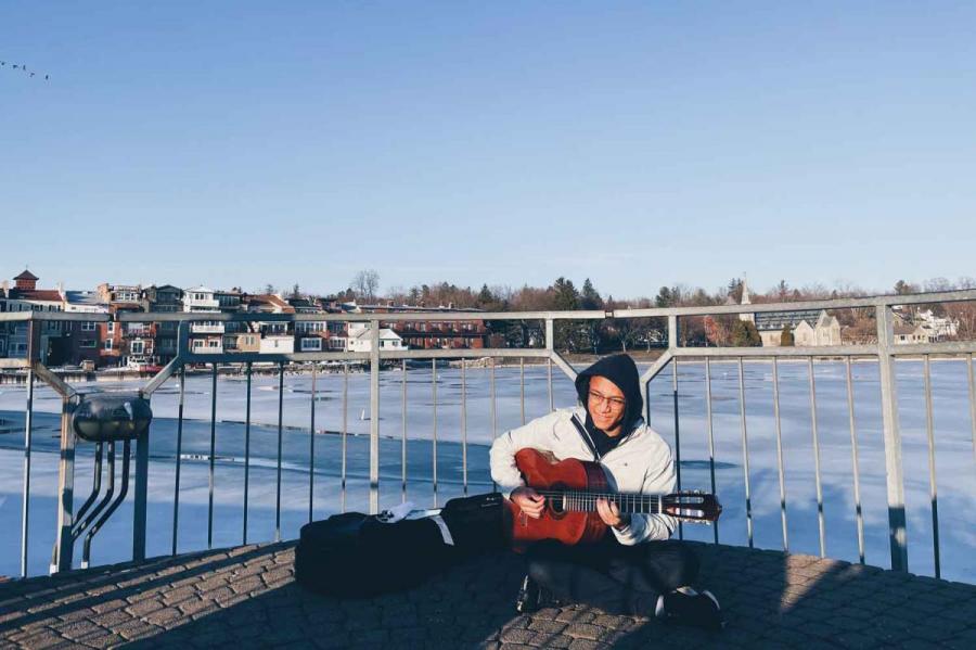 Man playing guitar on a dock