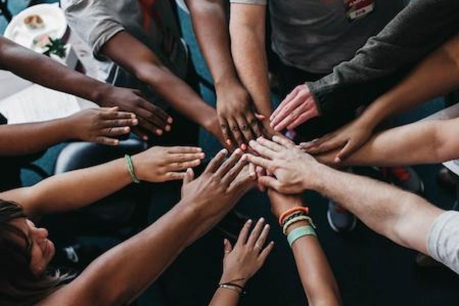 People placing their hands together in a circle