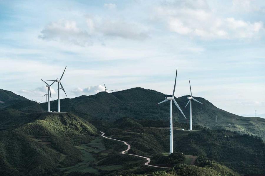 Wind turbines in a green, hilly landscape