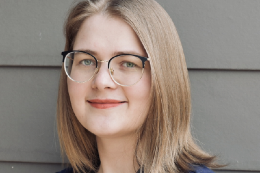 Ekaterina Landgren, long blonde hair and glasses with a blue shirt, smiling
