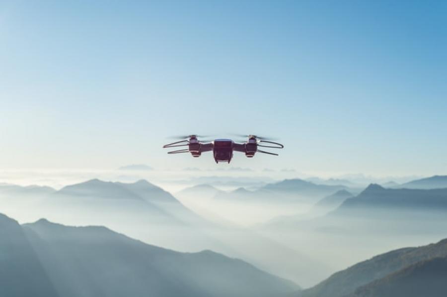 Drone flying in the air with mountains in the background
