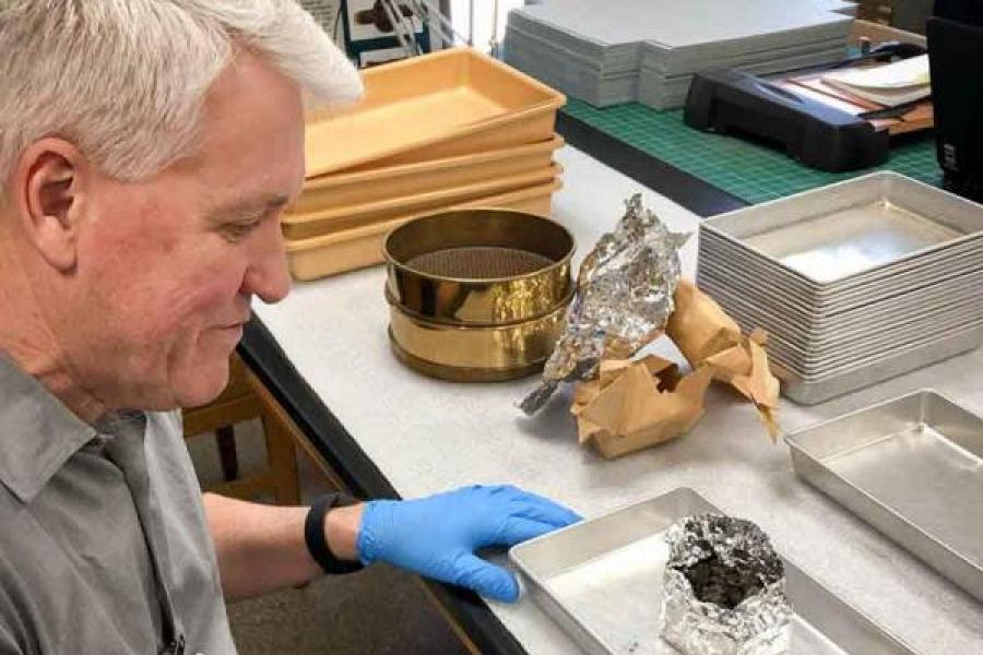 man looking at a piece of charcoal